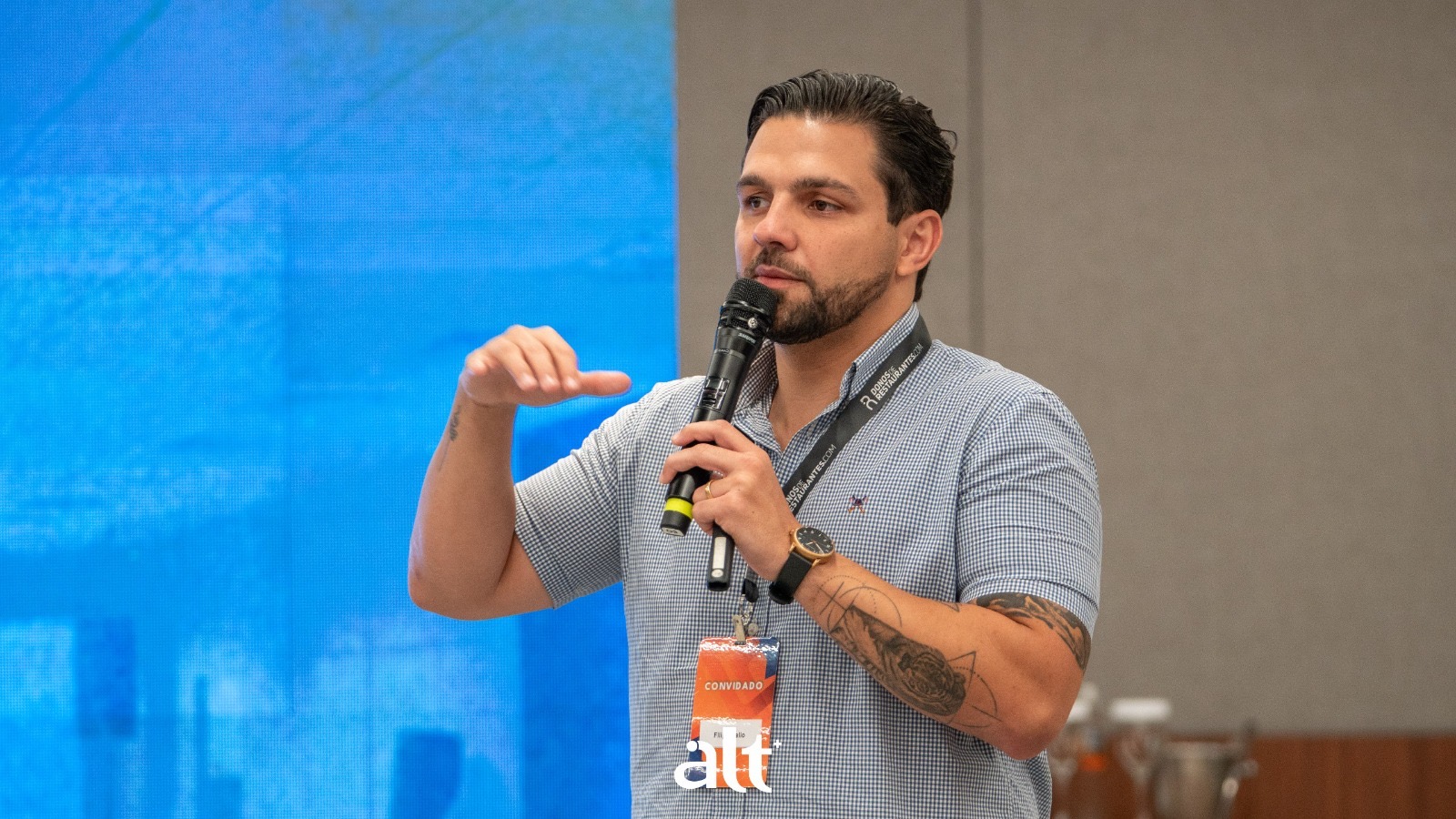 Filipe Mello com microfone durante palestra para donos de restaurantes